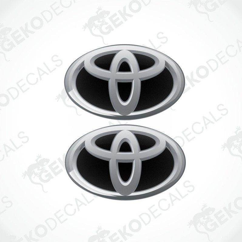 Two Toyota branded vinyl stickers with a dome shape and a silver and black color scheme.