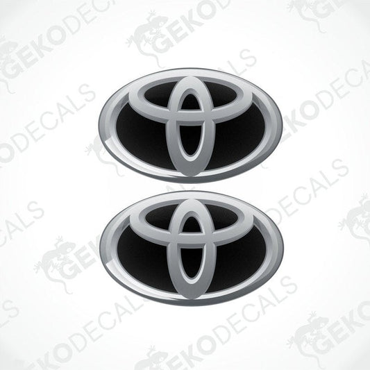 Two Toyota branded vinyl stickers with a dome shape and a silver and black color scheme.