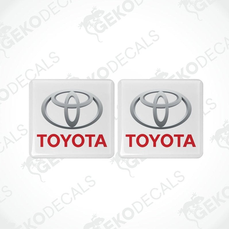 Two withe vinyl stickers with the Toyota logo in red and white.