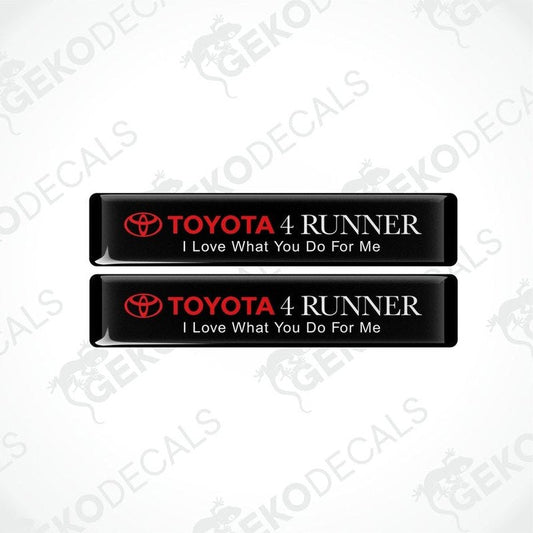 Two black rectangular car decals with white text, one saying 'TOYOTA 4 RUNNER' and the other with the phrase 'I Love What You Do For Me'.