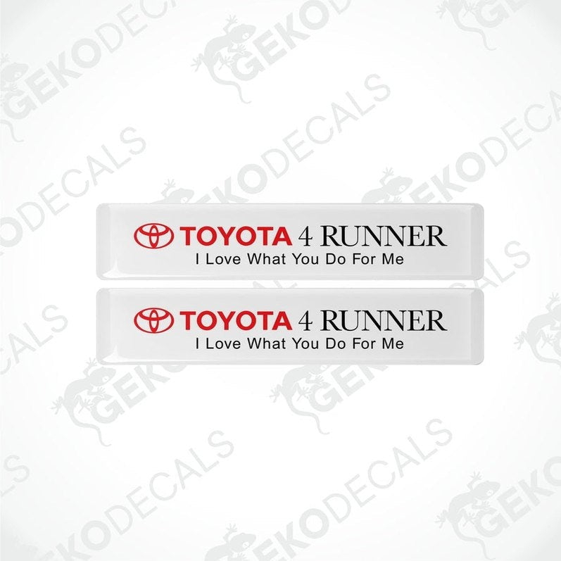 Two withe rectangular car decals with blacktext, one saying 'TOYOTA 4 RUNNER' and the other with the phrase 'I Love What You Do For Me'.