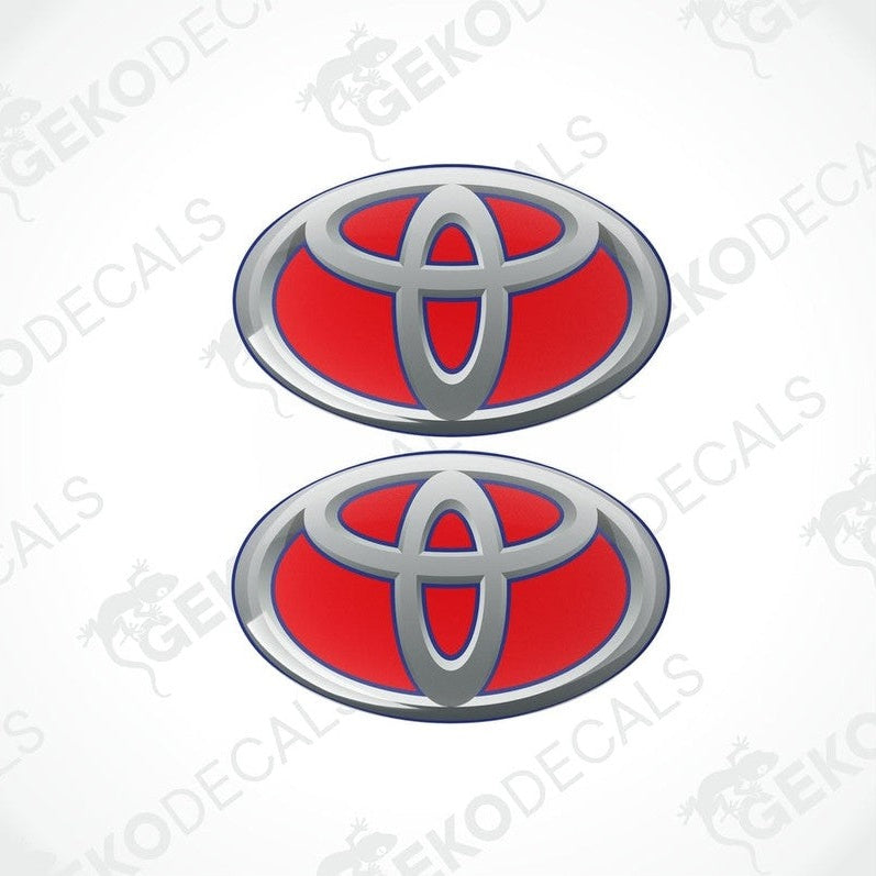 Two blue and silver Toyota branded vinyl stickers with a dome shape and a polyurethane coating.