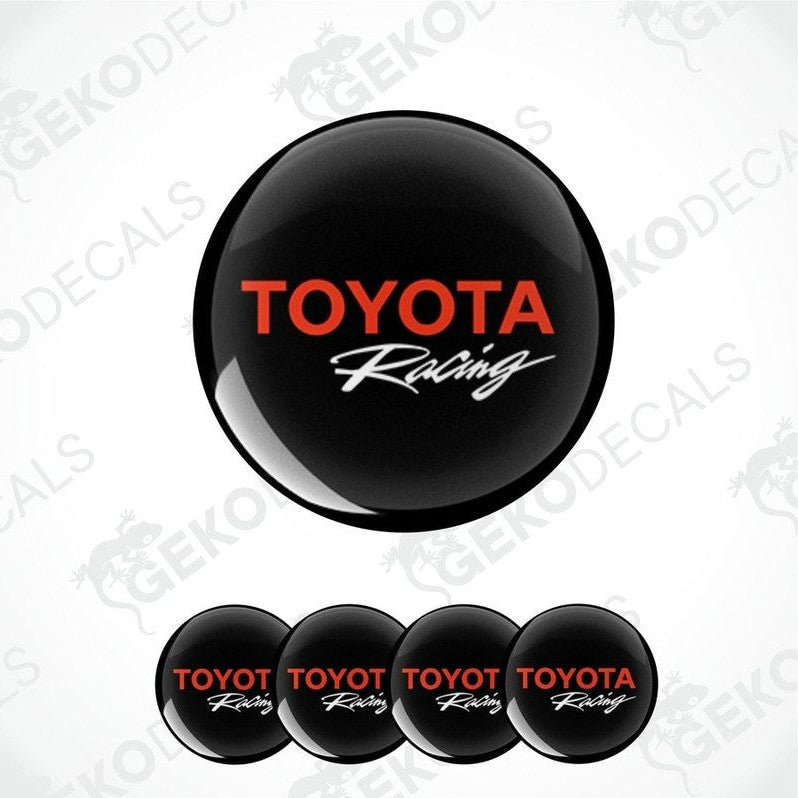A set of four black vinyl decals with the red text 'TOYOTA Racing' on them, displayed against a white background.