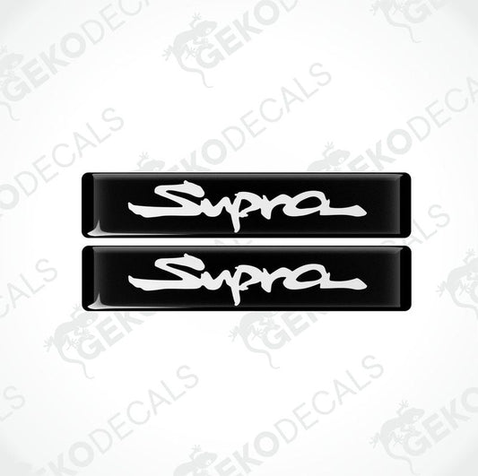 Two black vinyl stickers with the word 'SUPRA' written in white.