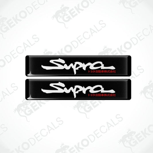Two black vinyl stickers with the word 'SUPRA' written in white.