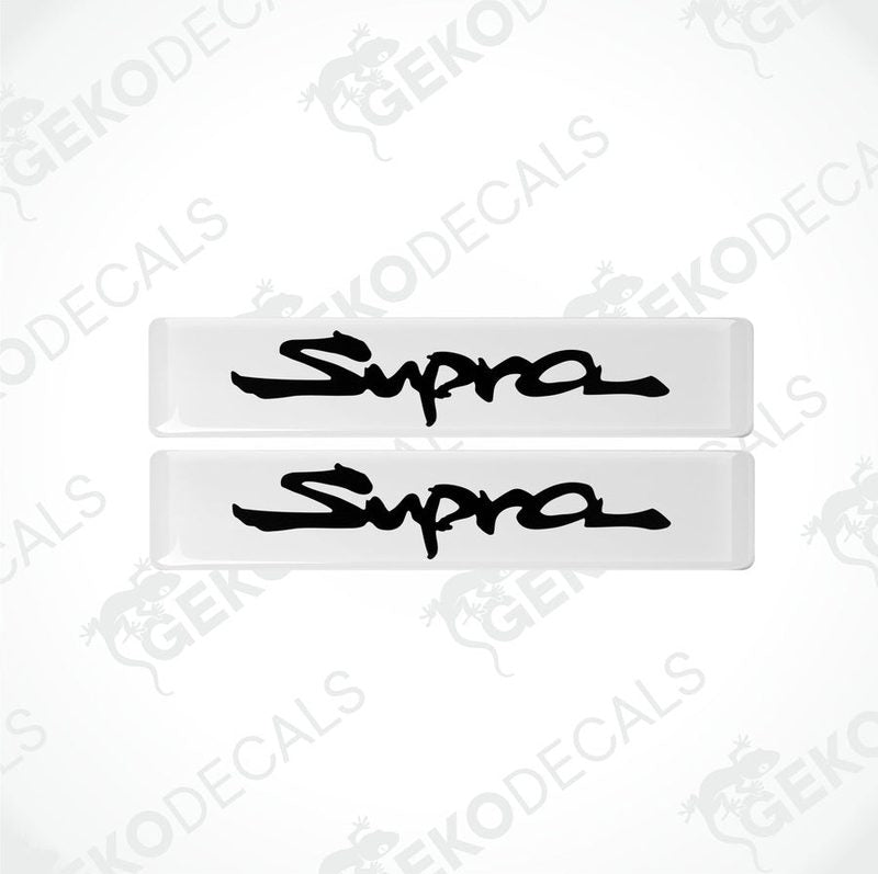 Two withe vinyl stickers with the word 'SUPRA' written in black.