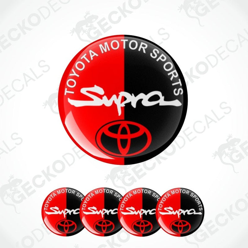 Toyota Motor Sports text at the edge, big white Supra logo in center with red toyota logo epoxy decal, multiple variants on a white background.