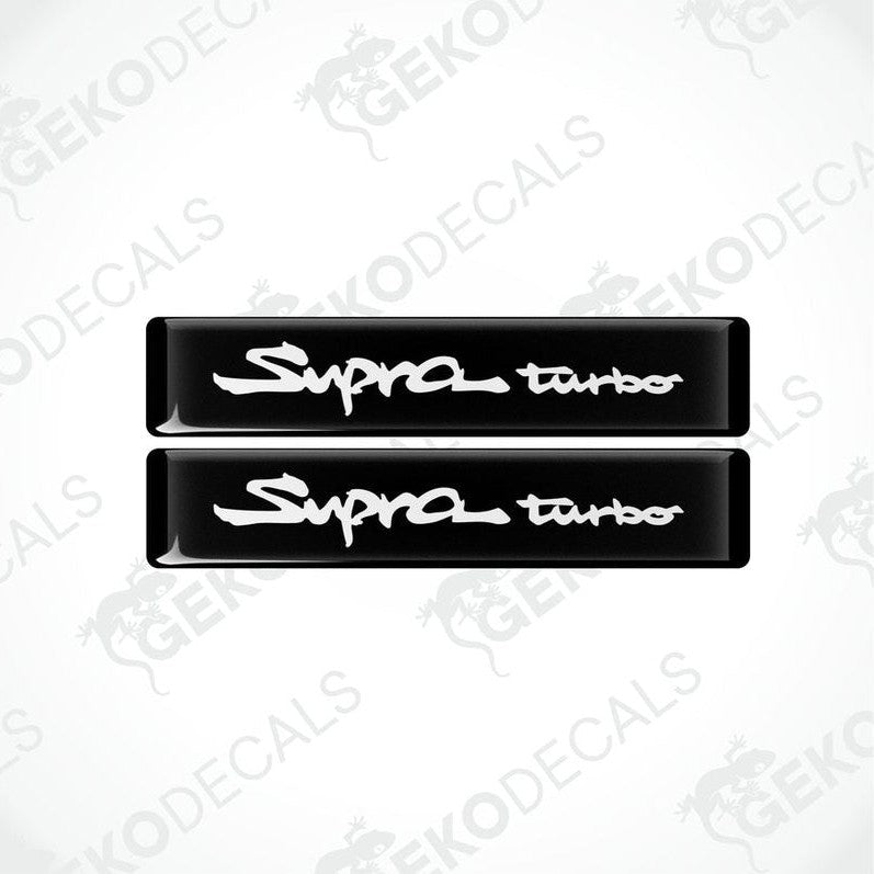 Two black vinyl decals with 'Supra turbo' text in white, indicating a set of car stickers for a Toyota Supra vehicle.