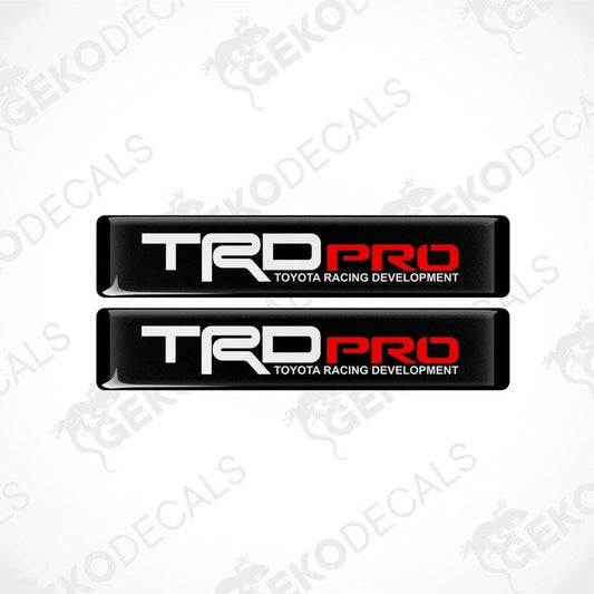 Two black vinyl stickers with red and white text 'TRD PRO' and 'TOYOTA RACING DEVELOPMENT', placed on a white background.