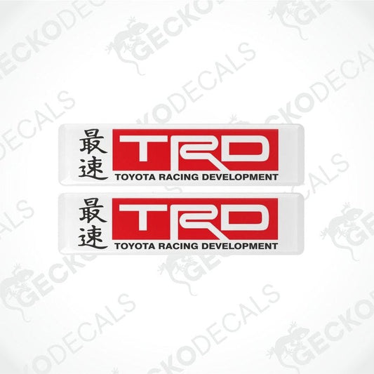 two red and black Toyota Racing Development logos on a white background with hieroglyphs in front