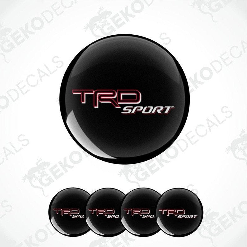 A set of black, red, and white vinyl decals with the TRD SPORT logo, designed for vehicle wheel caps.
