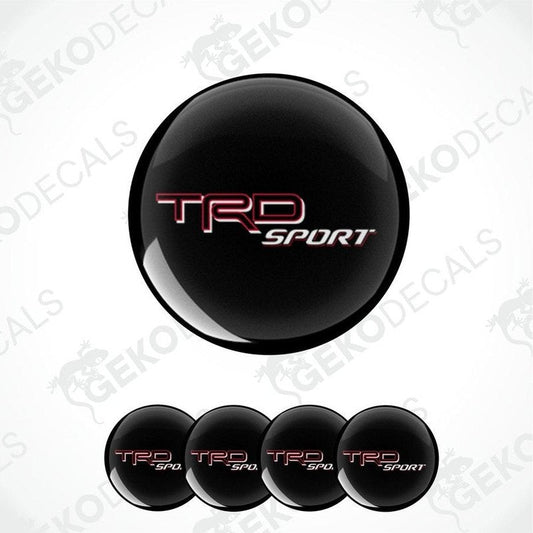 A set of black, red, and white vinyl decals with the TRD SPORT logo, designed for vehicle wheel caps.
