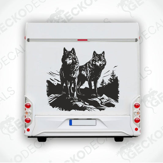 A black die cut decal of two wolves on the edge of a cliff, intended for use on vehicles or other surfaces.