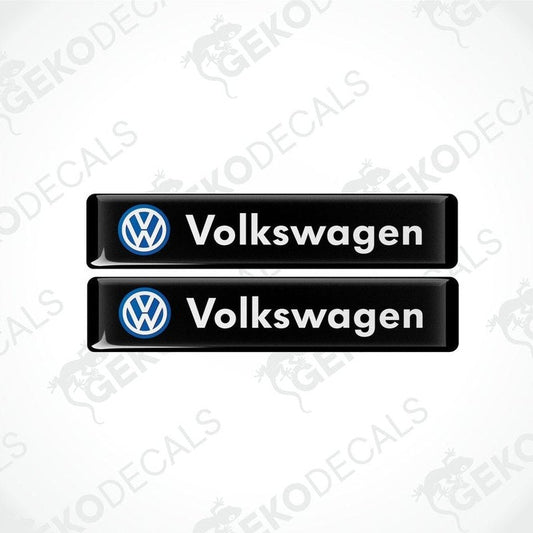 Two black vinyl stickers with the word 'VOLKSWAGEN' written in white and a blue logo of the same name.