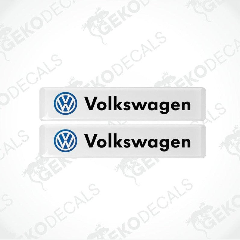 Two withe vinyl stickers with the word 'VOLKSWAGEN' written in black and a blue logo of the same name.