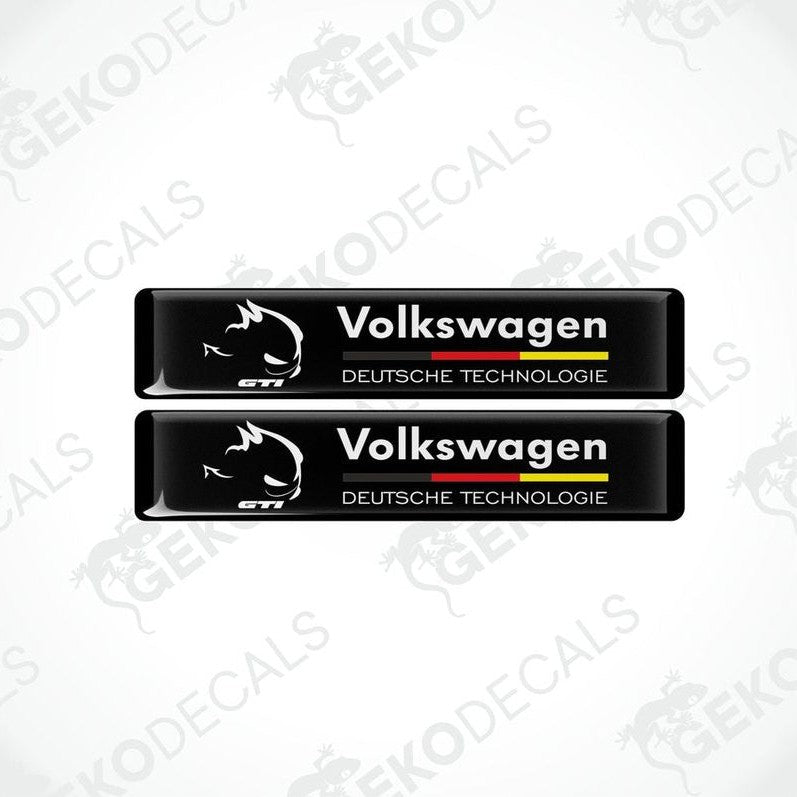 Two rectangular black vinyl decals with 'Volkswagen' and 'DEUTSCHES TECHNOLgie' text in white and red-yellow colors