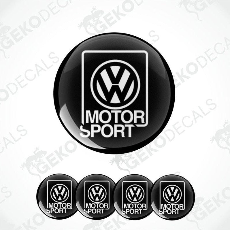 A set of four black vinyl stickers with the word 'MOTORSPORT' and the Volkswagen logo on each sticker.