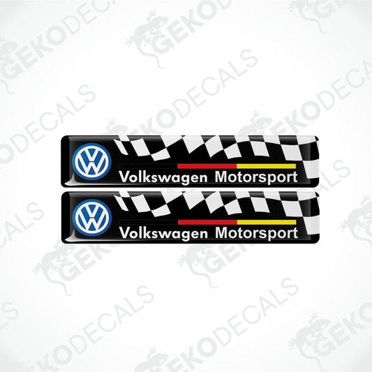 Two vinyl stickers with the Volkswagen Motorsport logo, featuring a black and white checkered pattern with red and yellow stripes.