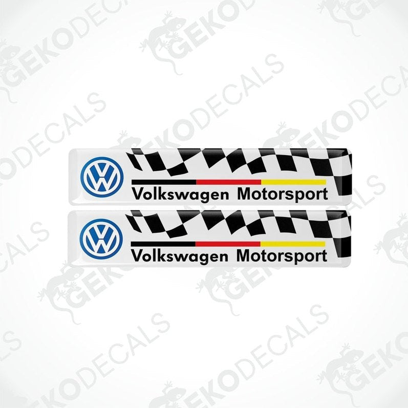 Two vinyl stickers with the Volkswagen Motorsport logo, featuring a withe and black checkered pattern with red and yellow stripes.