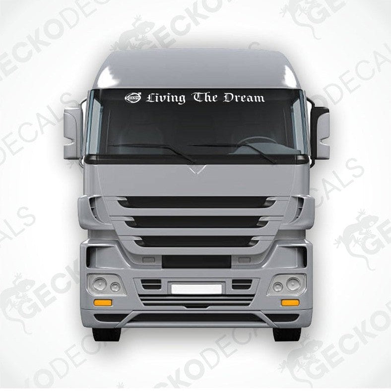 A die cut decal with the phrase 'Living The Dream' displayed on the front windscreen of a Volvo truck.