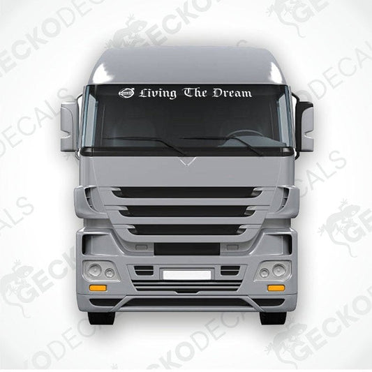 A die cut decal with the phrase 'Living The Dream' displayed on the front windscreen of a Volvo truck.