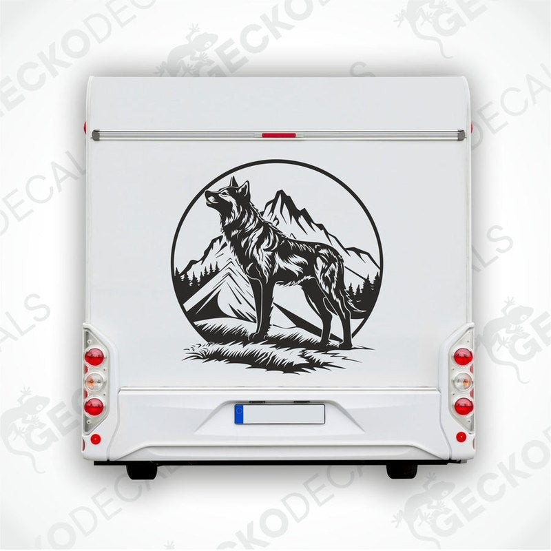 A black decal of a wolf howling with mountains in the background, intended for use on the rear of a vehicle.