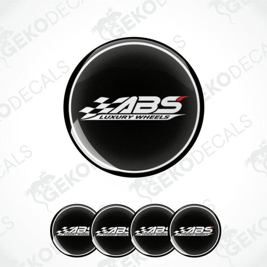 A set of four round black vinyl stickers with the text 'ABS Luxury Wheels' in white and red.