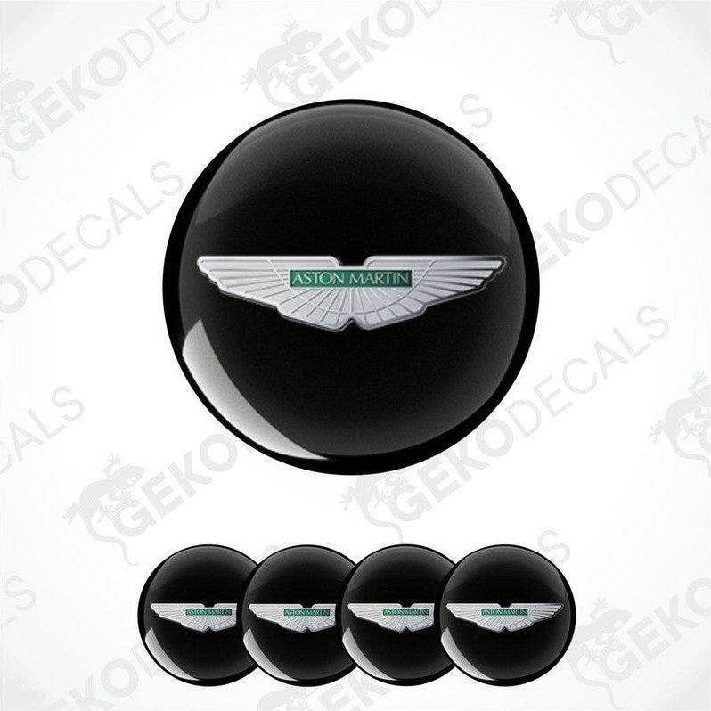 A set of four black vinyl stickers with a white Aston Martin logo on each.