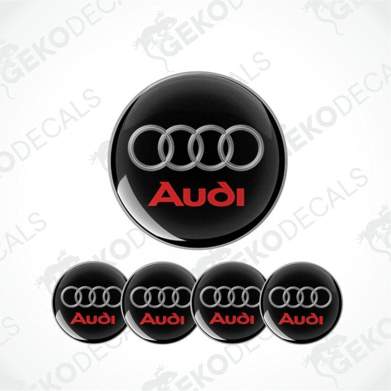 A set of four black vinyl stickers with the word 'AUDI' in red, displayed on a white background.