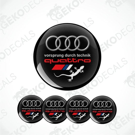 A set of four black vinyl stickers with the Audi Quattro branding and a design that includes a snake, likely intended for application on car wheels or caps.