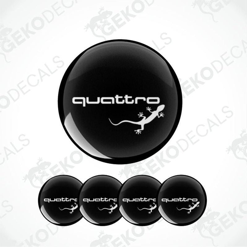 A set of four black vinyl stickers with the word 'AUDI QUATTRO' and an image of a lizard. 