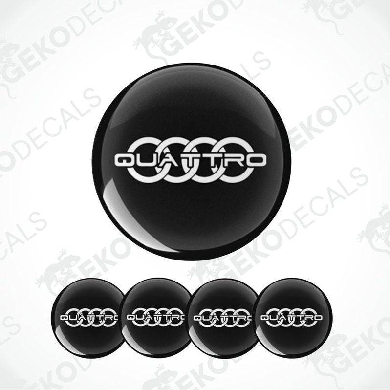 A set of four black vinyl stickers with the word 'QUATTRO' embossed on them, presented on a white background.