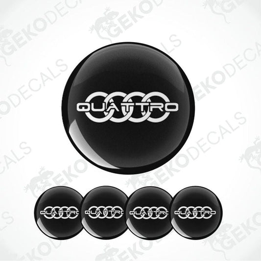 A set of four black vinyl stickers with the word 'QUATTRO' embossed on them, presented on a white background.