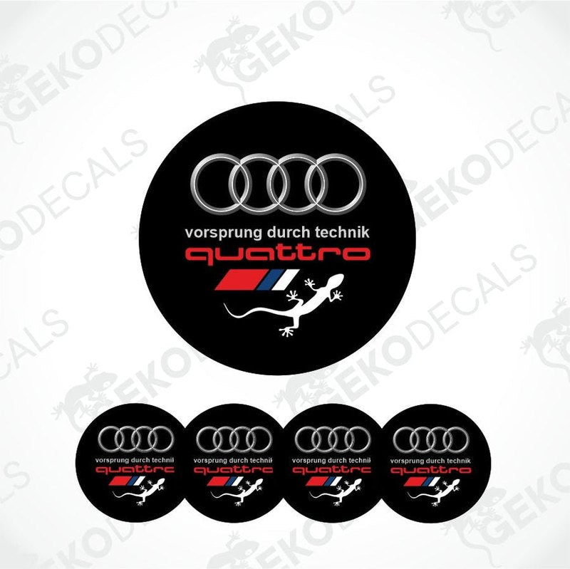 A set of four black vinyl stickers with the Audi Quattro branding and a design that includes a snake, likely intended for application on car wheels or caps.