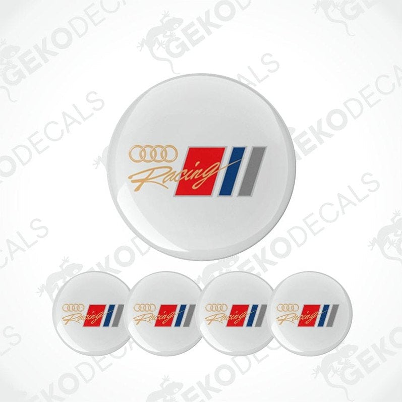 A set of four white round car decals with 'Audi Racing' logo in red, blue, and gray.