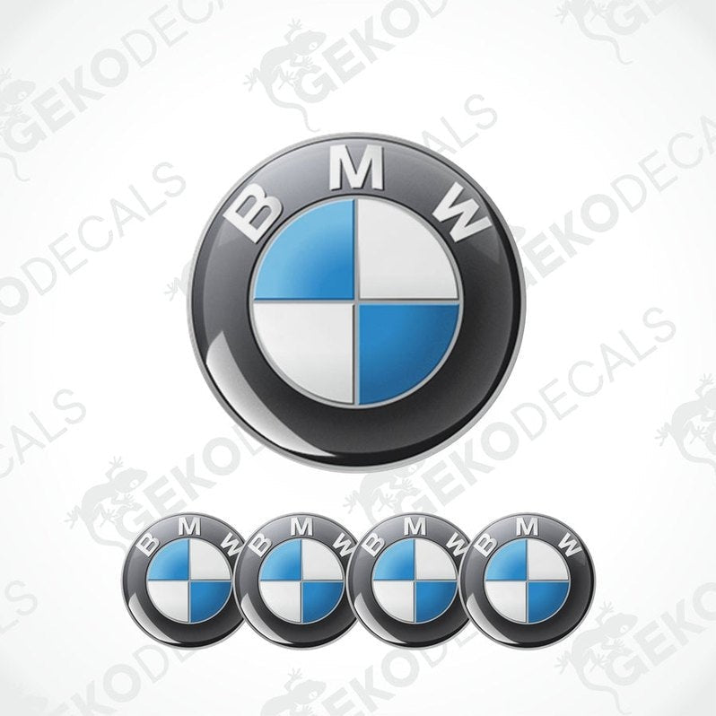 A set of four BMW emblem stickers, with one large emblem in the center and three smaller ones around it, all in black, blue, and white colors.
