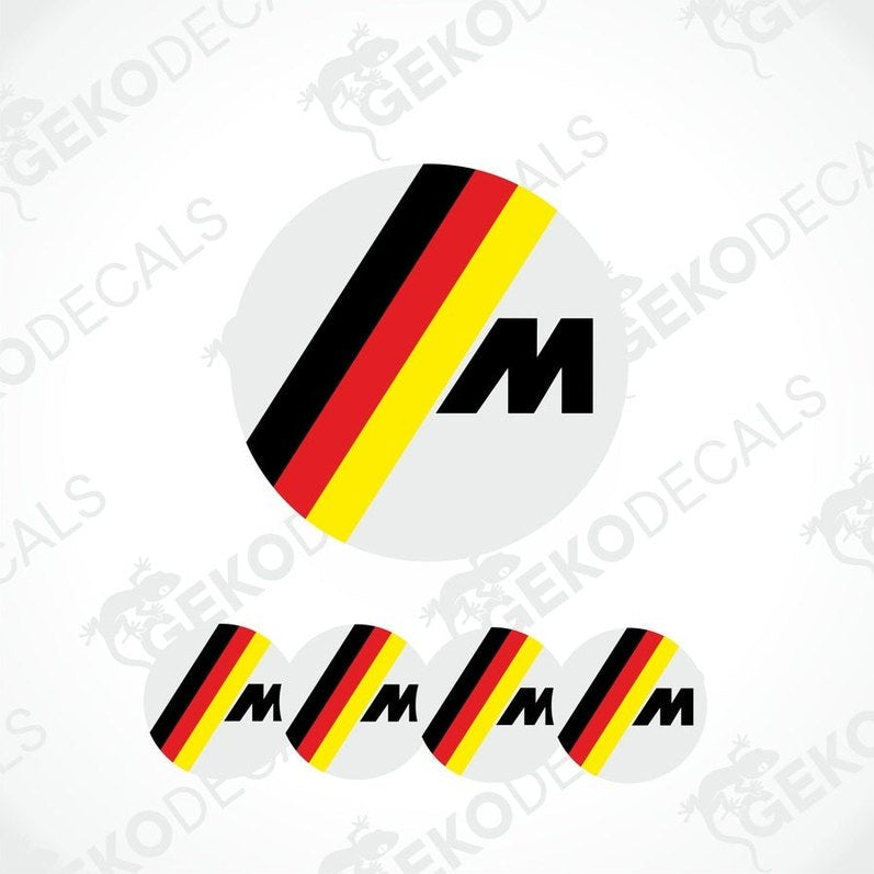 A set of four round vinyl stickers with a black, red, and yellow geometric pattern and the letter 'M' in the center, associated with BMW branding.