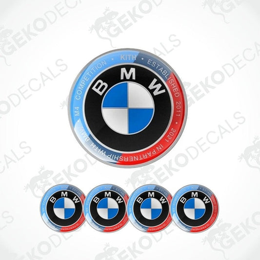 Set of vinyl decals with polyurethane coating for BMW M 4 COMPETITION, including one large emblem decal and four smaller ones for wheels.