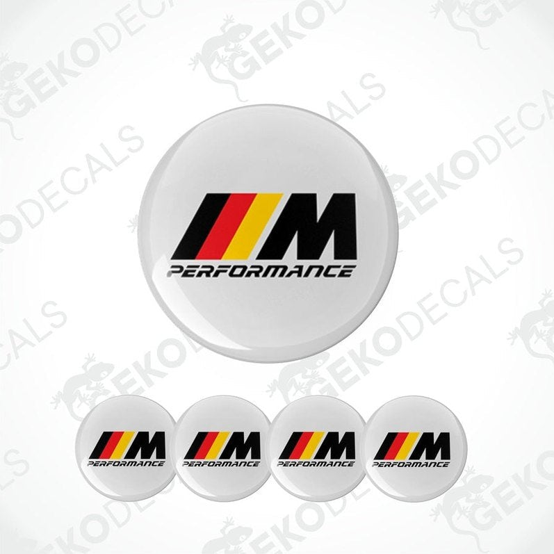 A set of four white vinyl stickers with the BMW M Performance logo in black, red, and yellow.