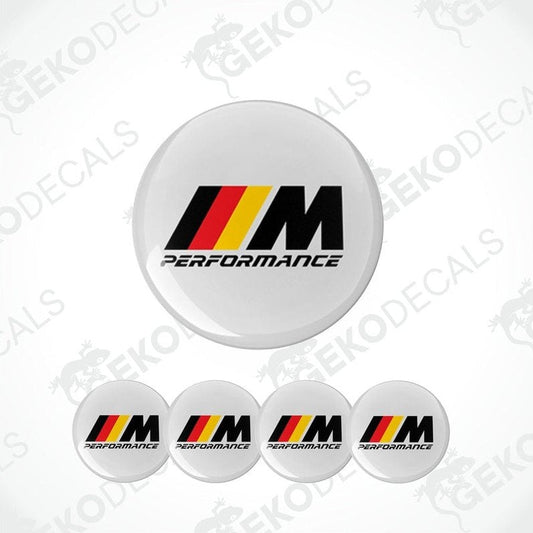 A set of four white vinyl stickers with the BMW M Performance logo in black, red, and yellow.
