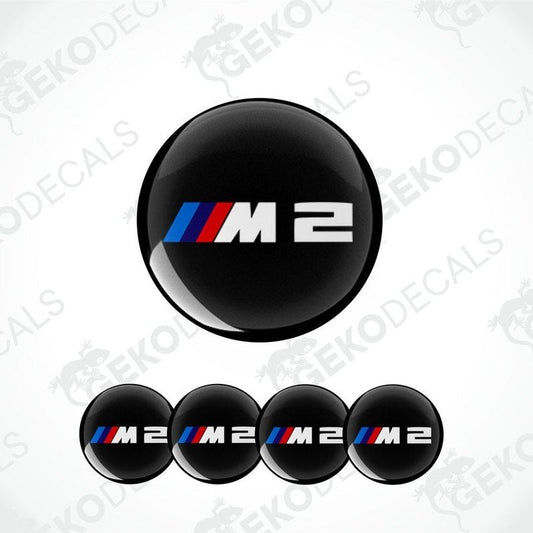 A set of four black vinyl stickers with the BMW M2 logo, displayed on a white background.