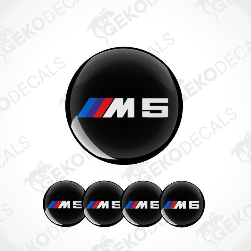 A set of four black vinyl stickers with the BMW M5 logo, displayed on a white background.