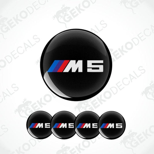 A set of four black vinyl stickers with the BMW M5 logo, displayed on a white background.