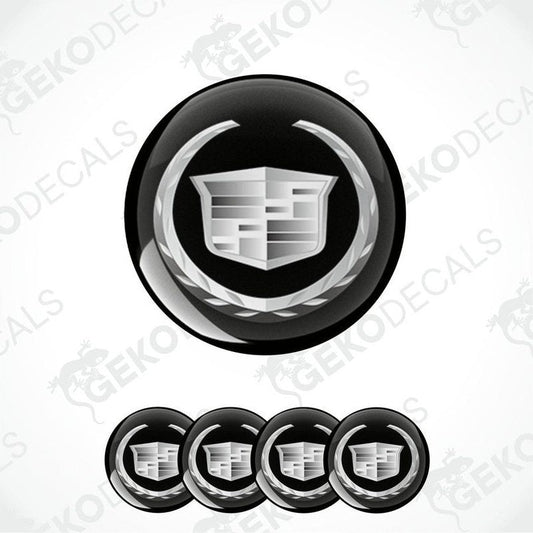 A set of black and white vinyl decals with a Cadillac logo design, intended for use as car wheel caps.