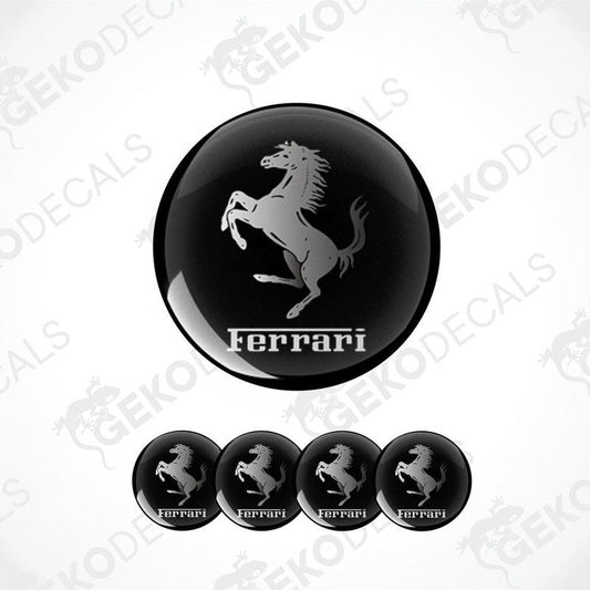 A set of four black vinyl stickers with a white Ferrari logo, designed for use on car wheels or caps.