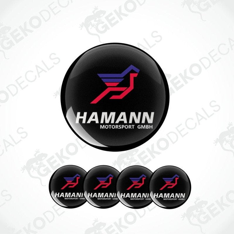 A set of four black vinyl stickers with red and blue geometric designs, featuring the brand name 'HAMANN' and the text 'Motorsport GMBH'.