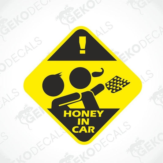 A yellow and black diamond-shaped car sticker with text and an exclamation mark, indicating 'HONEY IN CAR'.