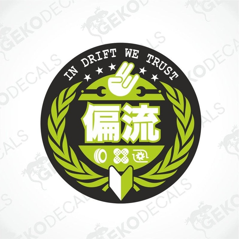 A circular car sticker with green laurel wreath design and text that reads 'IN DRIFT WE TRUST' along with some Japanese characters, and a hand gesture.