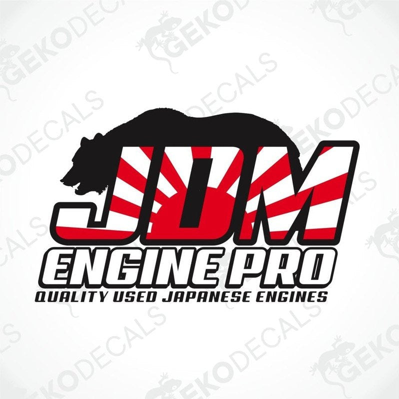 A sticker decal of JDM ENGINE PRO with a design that includes a bear, a flag, and the text 'QUALITY USED JAPANESE ENGINES'. The decal has a predominantly black, red, and white color scheme.