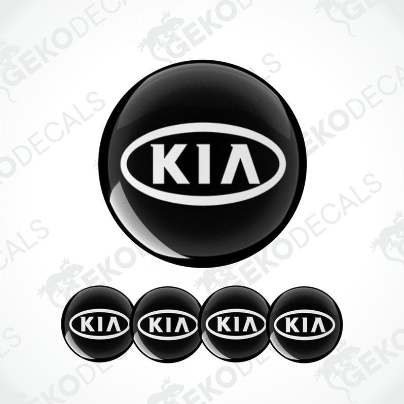A set of four black vinyl stickers with the KIA brand logo on them.